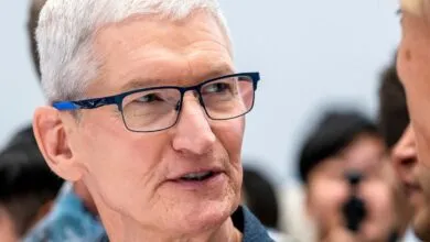 Close-up of Tim Cook, Apple CEO, wearing blue glasses.