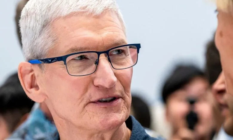 Close-up of Tim Cook, Apple CEO, wearing blue glasses.