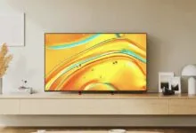 Modern living room with a flat-screen TV displaying vibrant abstract art.