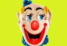 Vintage clown face with red nose and blue hat against a bright green background.