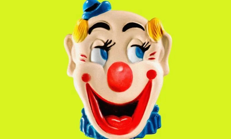 Vintage clown face with red nose and blue hat against a bright green background.
