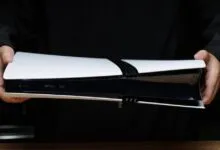 Hands hold a PlayStation 5 console, showcasing its design.