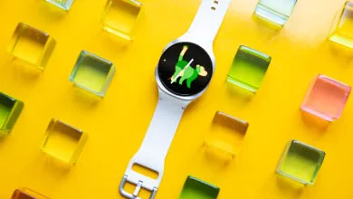 Smartwatch with monkey face on yellow background with colorful blocks.