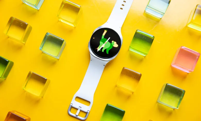 Smartwatch with monkey face on yellow background with colorful blocks.