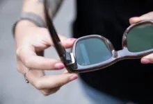 Close-up of Ray-Ban Meta smart glasses held by a person.