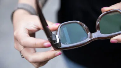 Close-up of Ray-Ban Meta smart glasses held by a person.