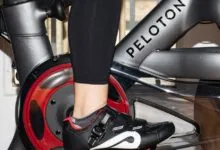 Close-up of a person's foot clipped into a Peloton bike pedal.