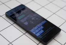 Smartphone displaying 'The Verge' article about Lego Smart Brick review.