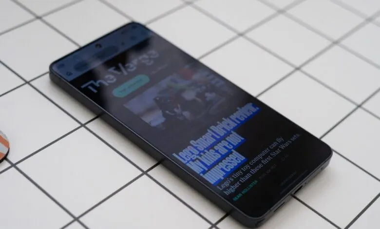 Smartphone displaying 'The Verge' article about Lego Smart Brick review.