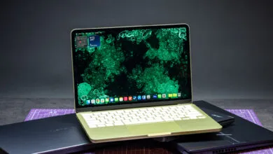 MacBook on top of Lenovo and Acer laptops, showcasing tech comparison.