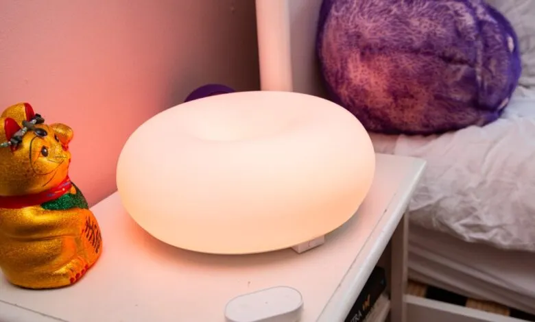 IKEA Varmblixt lamp glows next to a golden lucky cat figurine.