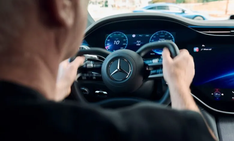Driver's view of Mercedes-Benz steering wheel and digital dashboard.