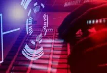 Hands typing on a keyboard with digital overlay and red and blue lighting.