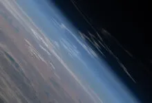 Earth's horizon from space, showing atmosphere and land.