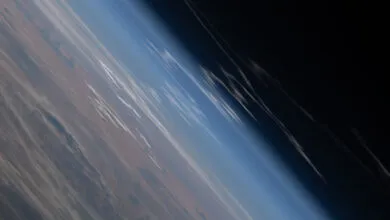 Earth's horizon from space, showing atmosphere and land.