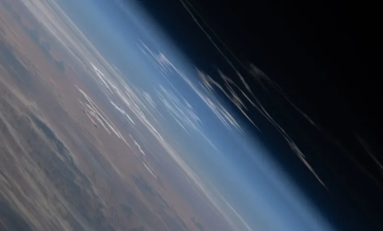 Earth's horizon from space, showing atmosphere and land.