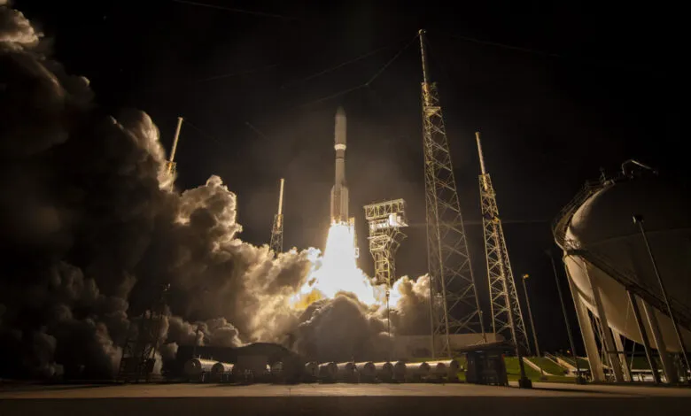 Rocket launching at night with bright flames and smoke.