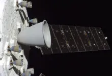 Orion spacecraft with solar array and engines against black space.