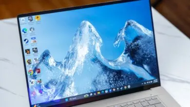 Close-up of an Asus Zenbook laptop screen displaying a blue water wave wallpaper.