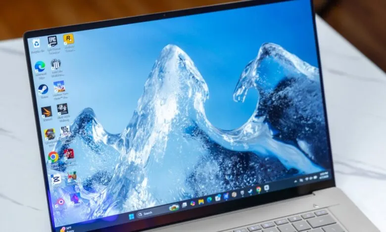Close-up of an Asus Zenbook laptop screen displaying a blue water wave wallpaper.