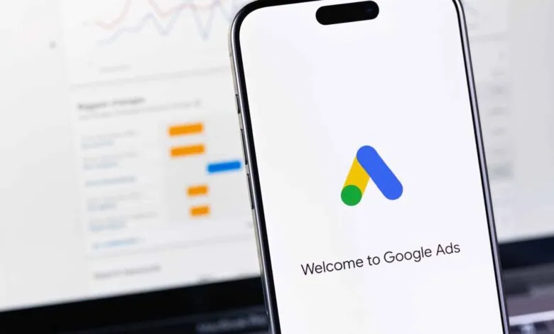 Google Ads logo on a phone screen with data charts in background.