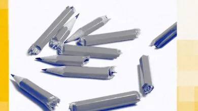 Scattered, broken pencils on a white surface with yellow accents.