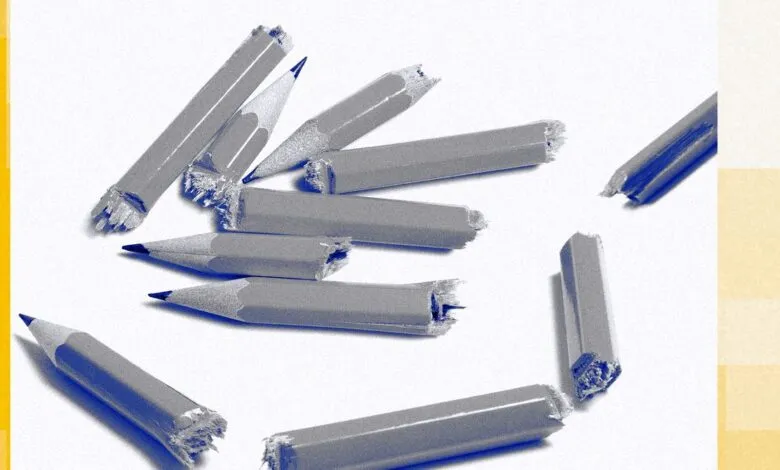 Scattered, broken pencils on a white surface with yellow accents.