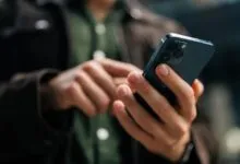 Close-up of hands using a blue smartphone, browsing on the go.