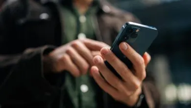 Close-up of hands using a blue smartphone, browsing on the go.