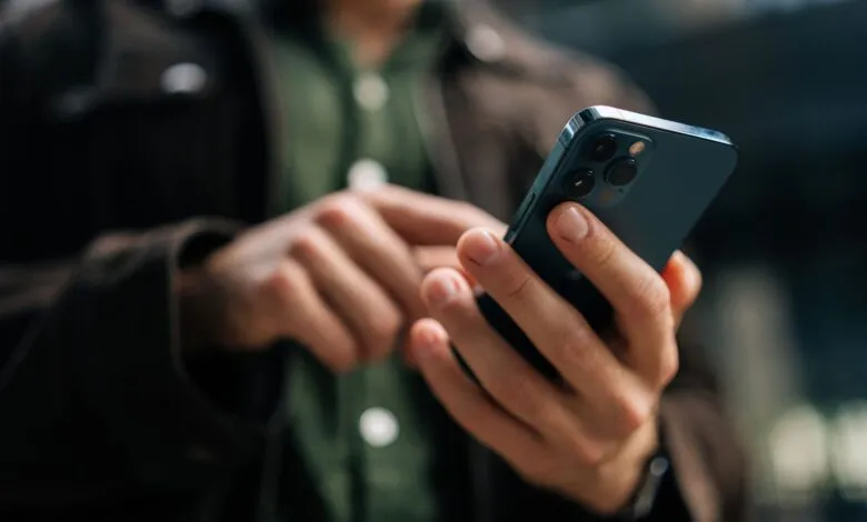 Close-up of hands using a blue smartphone, browsing on the go.