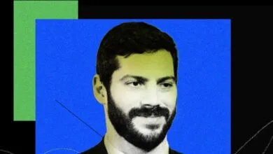 Portrait of Alex Bores with a beard against a blue and green background.