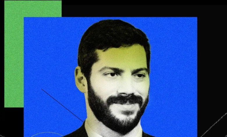 Portrait of Alex Bores with a beard against a blue and green background.