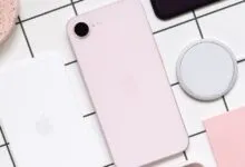 Pink iPhone SE with MagSafe charger on a grid background.