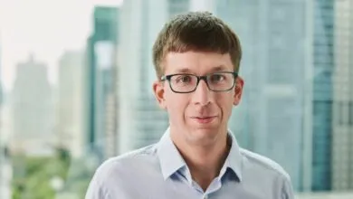 Headshot of Matei Zaharia, co-founder of Databricks, wearing glasses and a light blue shirt.