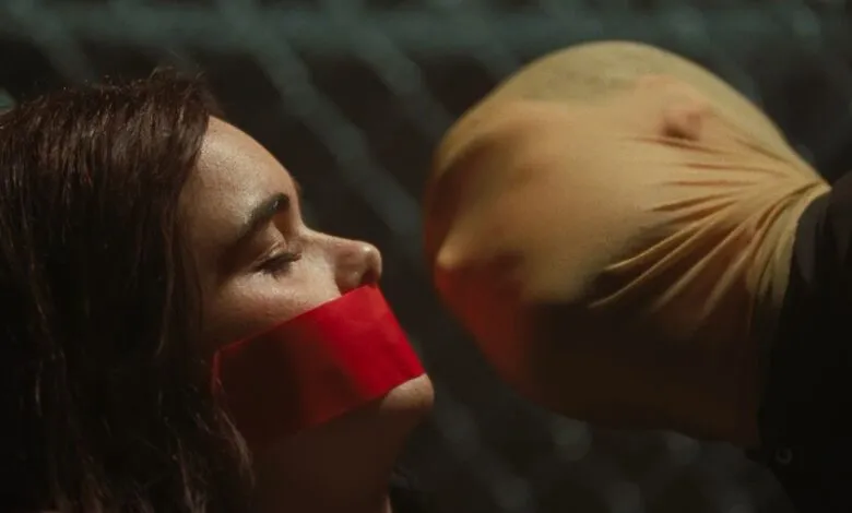 Woman with red tape over mouth faces person in stocking mask.