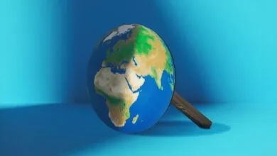 Globe with wooden handle on blue background, showing continents.