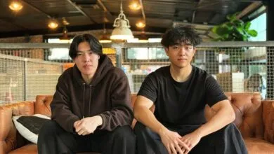 Edwin Wang (CTO) and Justin Jin (CEO) sit on a brown leather couch.