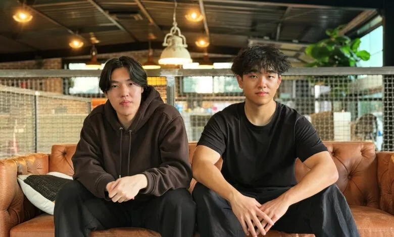 Edwin Wang (CTO) and Justin Jin (CEO) sit on a brown leather couch.