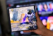 Foldable phone displays Genshin Impact gameplay in hand.