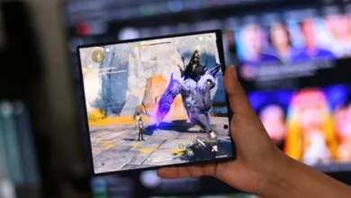 Foldable phone displays Genshin Impact gameplay in hand.
