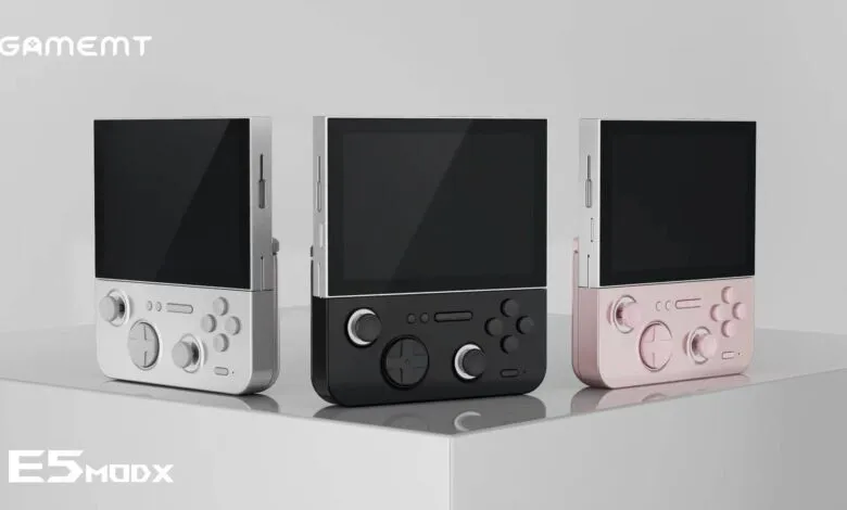 Three GameMT E5 ModX handheld consoles in silver, black, and pink.
