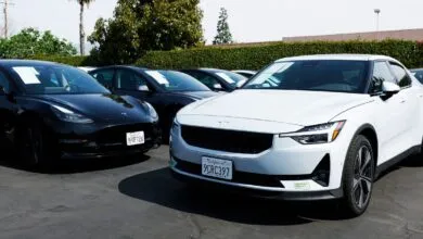 Used car lot featuring a white Polestar 2 and a black Tesla Model 3.