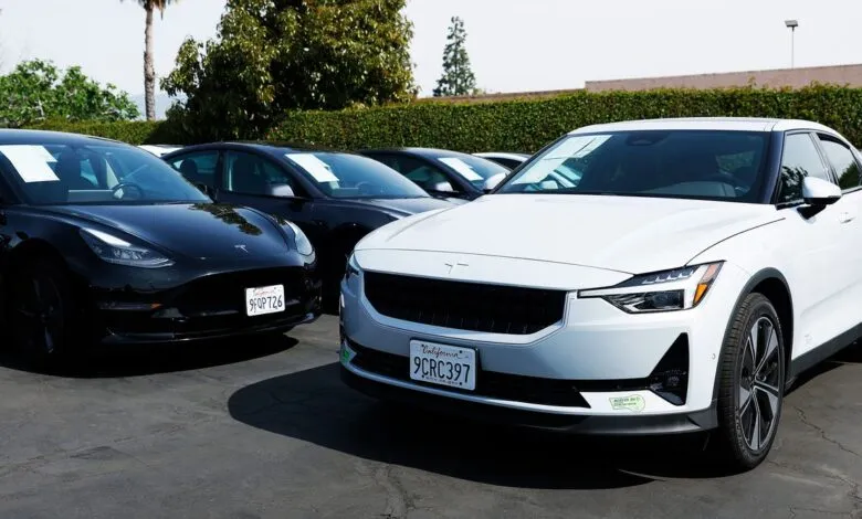Used car lot featuring a white Polestar 2 and a black Tesla Model 3.