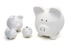 Four white piggy banks of varying sizes on a white background.