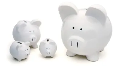 Four white piggy banks of varying sizes on a white background.