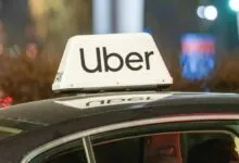 Uber car with illuminated sign on roof at night.