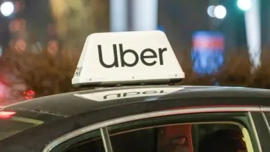Uber car with illuminated sign on roof at night.