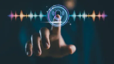 Finger touches glowing microphone icon on screen with sound waves.