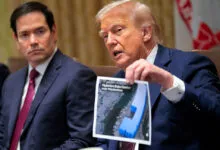 Donald Trump holds up a photo of a data center, Marco Rubio sits nearby.
