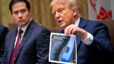 Donald Trump holds up a photo of a data center, Marco Rubio sits nearby.